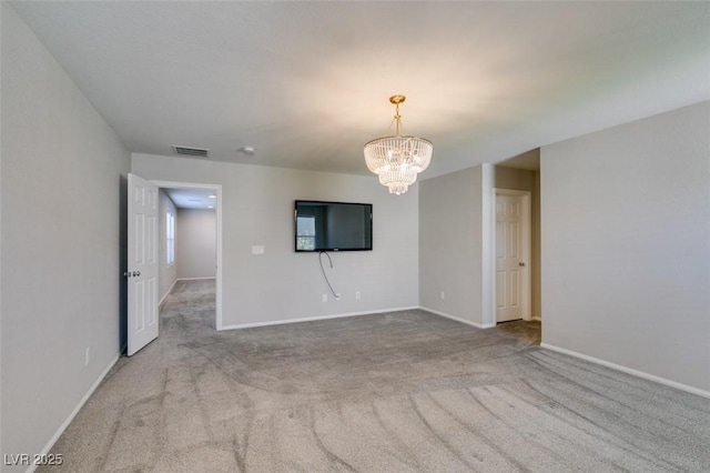 unfurnished room featuring light colored carpet and an inviting chandelier