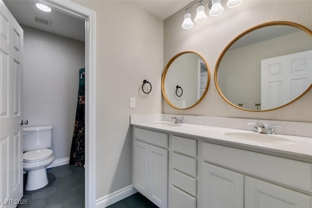 bathroom featuring vanity, tile patterned floors, and toilet