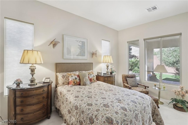 bedroom featuring light colored carpet and visible vents