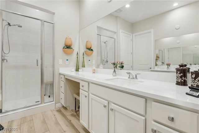 bathroom featuring recessed lighting, a stall shower, and vanity