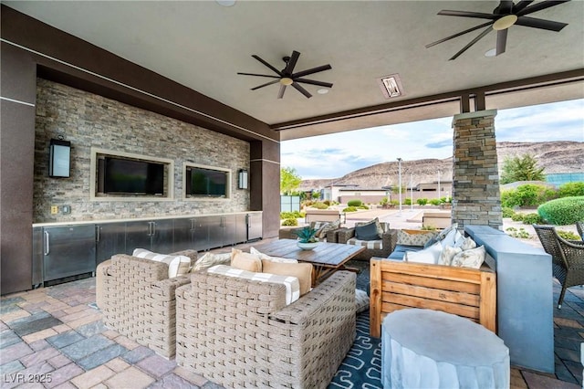 view of patio with area for grilling, an outdoor living space, and ceiling fan