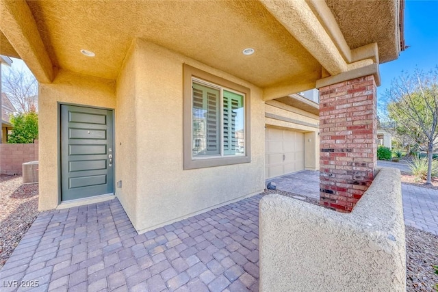 property entrance with central AC and a garage