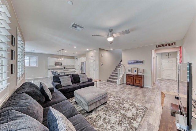 living room with sink, ceiling fan, and light hardwood / wood-style flooring