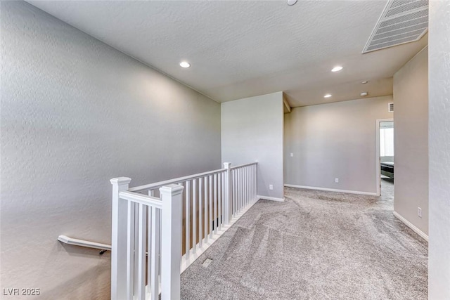 carpeted empty room featuring a textured ceiling