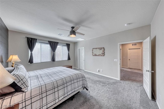 carpeted bedroom featuring ceiling fan and a textured ceiling