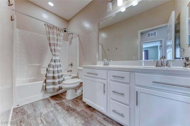 full bathroom featuring vanity, hardwood / wood-style floors, shower / bath combination with curtain, and toilet