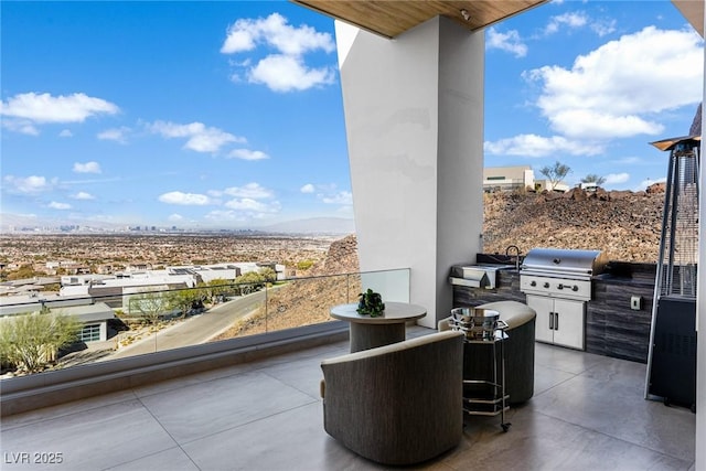 view of patio / terrace with an outdoor kitchen, a grill, sink, and a balcony