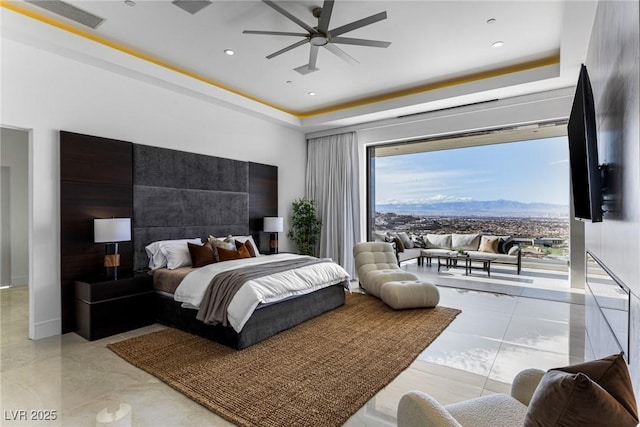 bedroom with ceiling fan, a raised ceiling, and access to outside