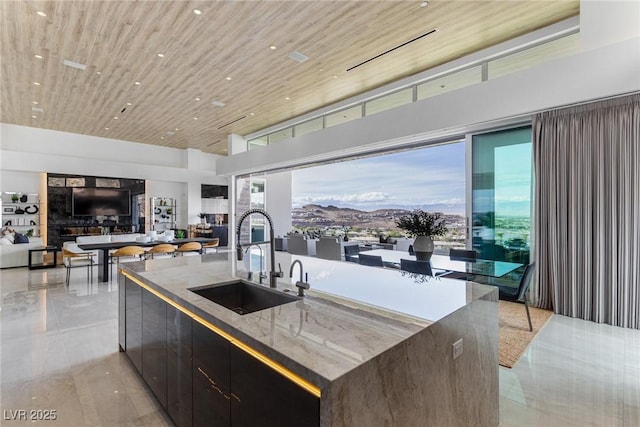 kitchen featuring wood ceiling, a spacious island, sink, and dark brown cabinets