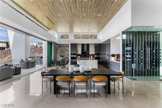 dining area with a towering ceiling and wood ceiling