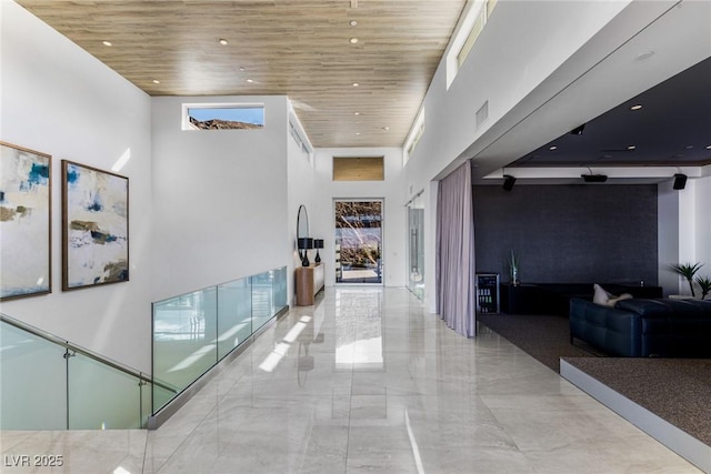 hall featuring wood ceiling and a high ceiling