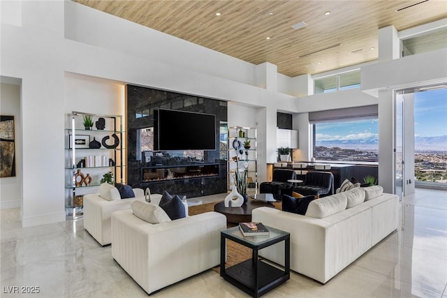 living room with a towering ceiling and wooden ceiling