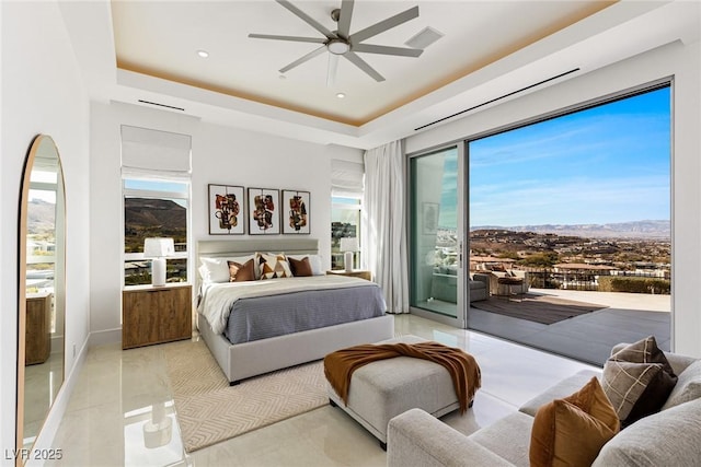 bedroom with access to exterior, ceiling fan, and a tray ceiling