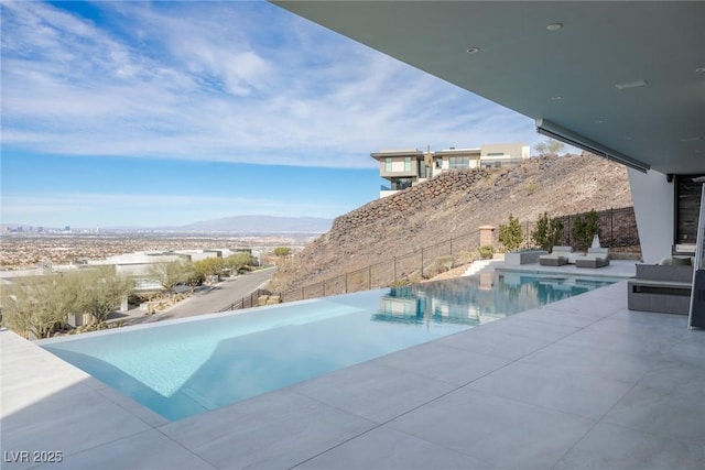 view of pool featuring a mountain view, an outdoor living space, and a patio