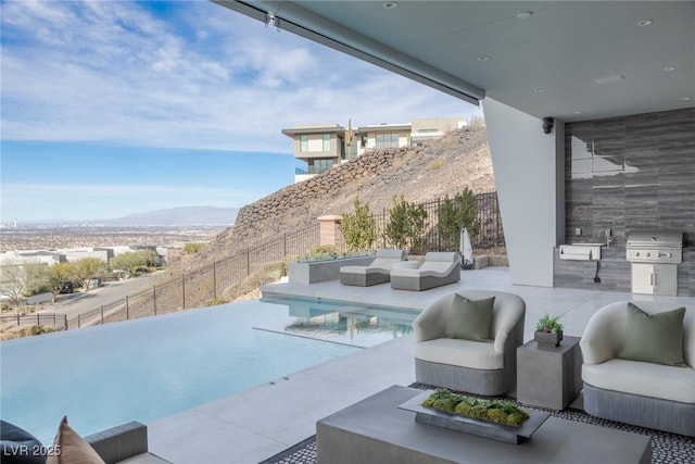 view of patio / terrace with a mountain view, a fenced in pool, outdoor lounge area, and a grill