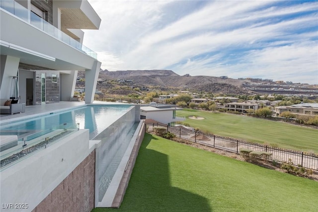 view of pool featuring a mountain view and a lawn