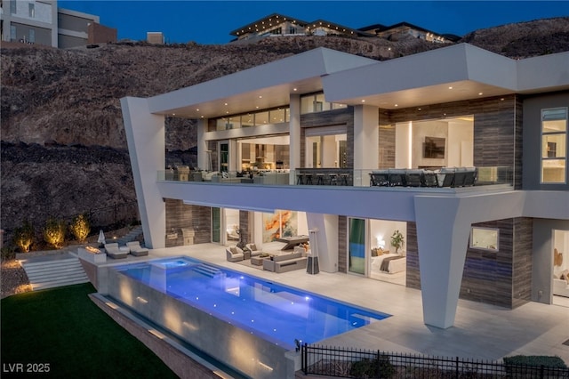 rear view of property featuring a patio, an outdoor hangout area, and a jacuzzi