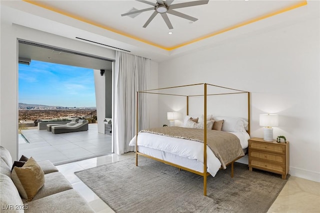 bedroom featuring access to outside, ceiling fan, and a tray ceiling