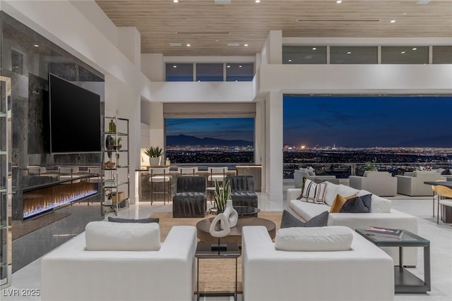 living room with a premium fireplace, a high ceiling, and wooden ceiling