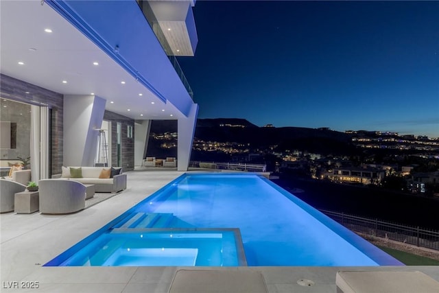 pool at twilight with an outdoor living space and a patio