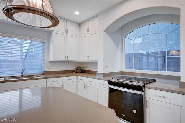 kitchen with white cabinetry, sink, and stainless steel range with gas stovetop