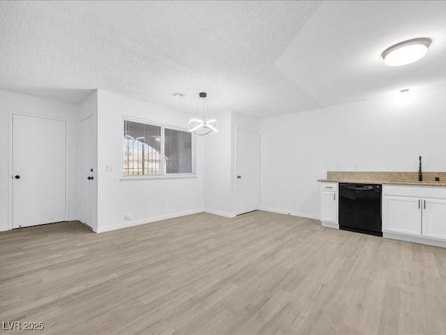 unfurnished living room featuring an inviting chandelier, sink, light hardwood / wood-style flooring, and a textured ceiling