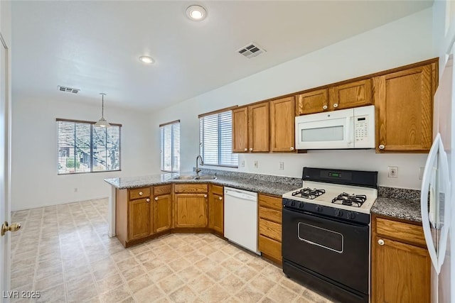 kitchen with sink, white appliances, decorative light fixtures, and kitchen peninsula