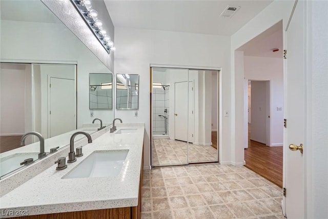 bathroom with a shower with door and vanity