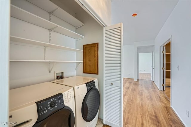 laundry room with independent washer and dryer and light hardwood / wood-style floors