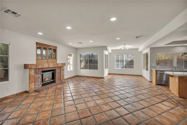 unfurnished living room featuring light tile patterned flooring and a brick fireplace