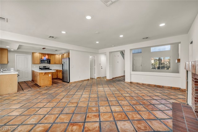 unfurnished living room featuring a fireplace, sink, and light tile patterned floors