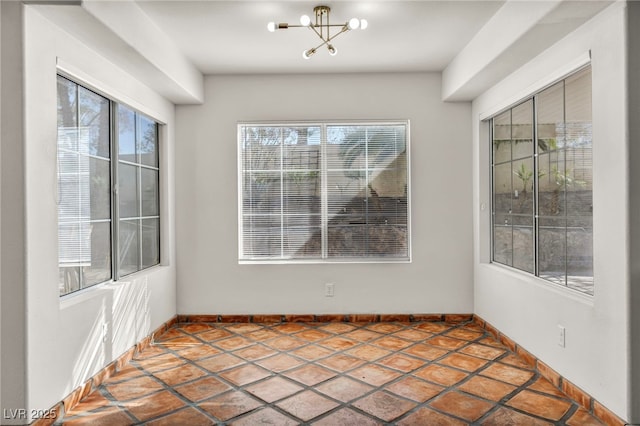 unfurnished dining area with a chandelier