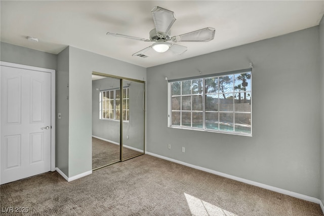 unfurnished bedroom with carpet, ceiling fan, and a closet