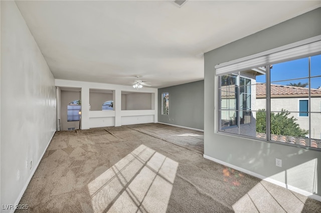 unfurnished living room featuring built in shelves, ceiling fan, and carpet floors