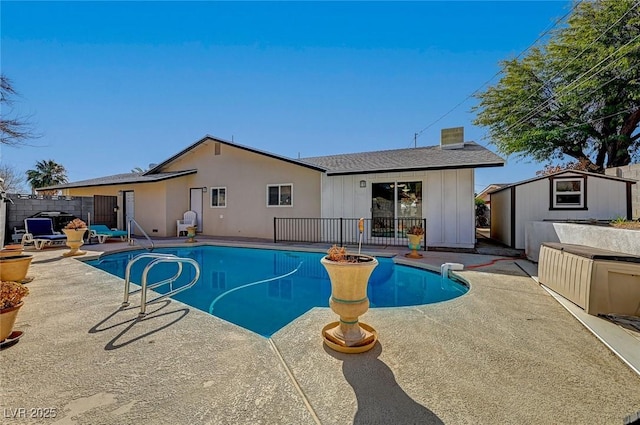 view of swimming pool featuring a shed and a patio area