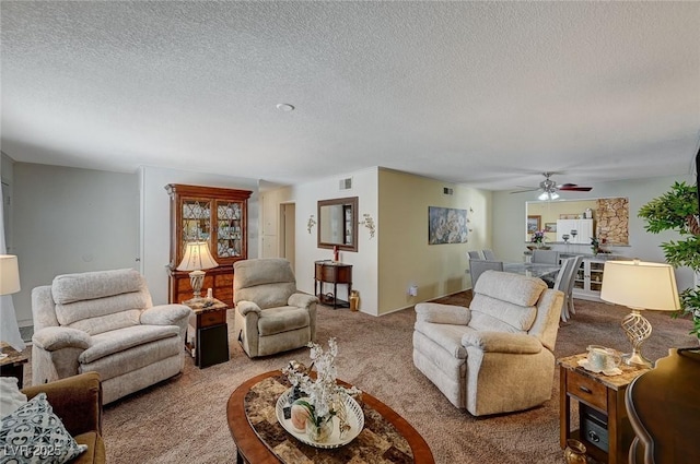 living room featuring light carpet, ceiling fan, and a textured ceiling