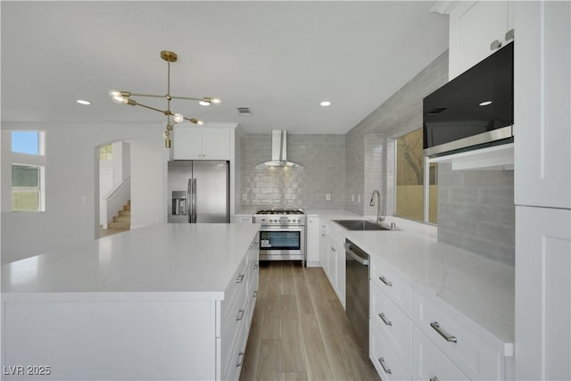 kitchen with sink, a center island, pendant lighting, stainless steel appliances, and white cabinets