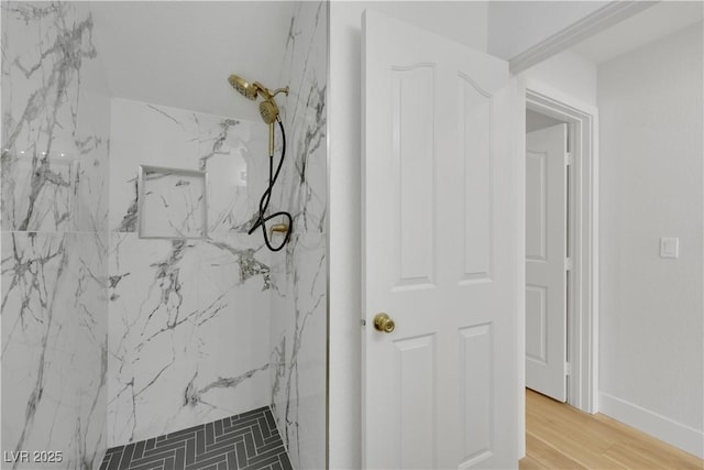 interior details with wood-type flooring and a tile shower