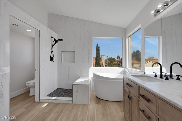 full bathroom featuring vanity, hardwood / wood-style floors, vaulted ceiling, and toilet