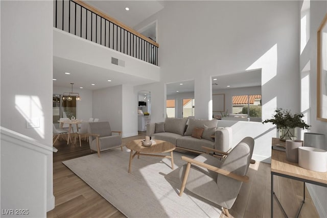 living room with a towering ceiling and light wood-type flooring