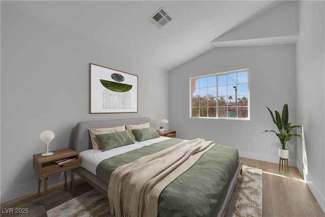 bedroom featuring wood-type flooring and vaulted ceiling