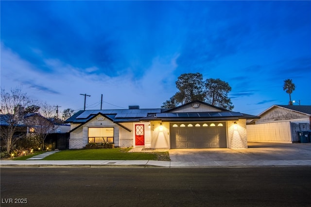 single story home featuring a garage, a yard, and solar panels