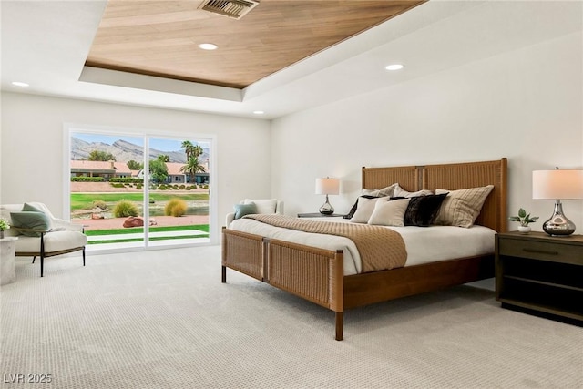 carpeted bedroom with wood ceiling and a tray ceiling