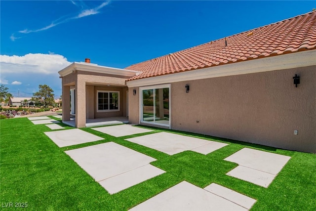 rear view of property with a yard and a patio area