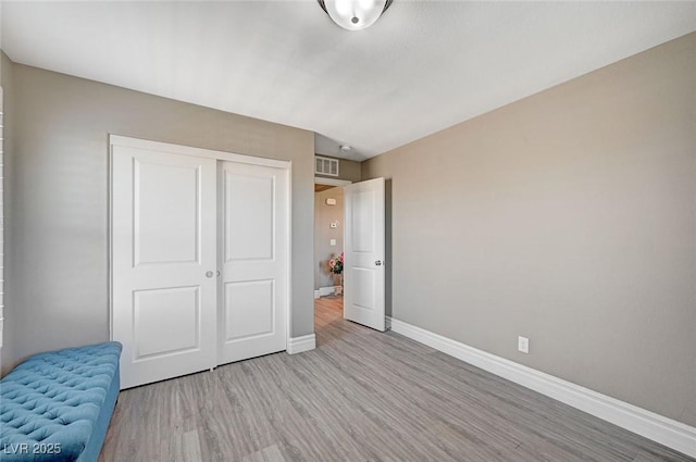 unfurnished bedroom with a closet and light wood-type flooring