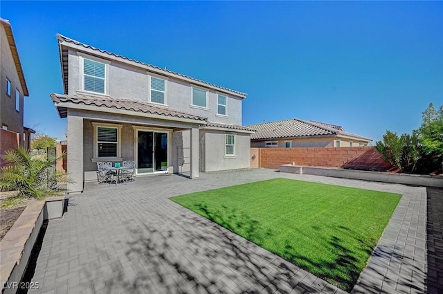 rear view of property featuring a patio and a lawn