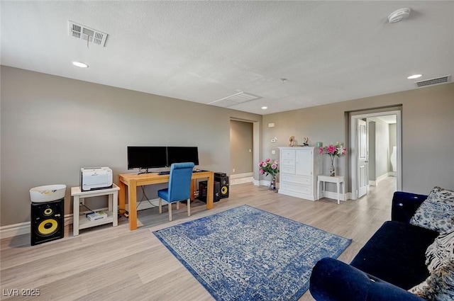 home office with hardwood / wood-style floors and a textured ceiling