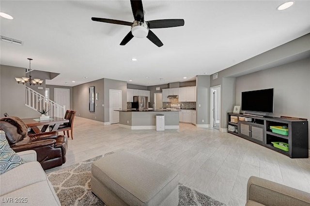 living room featuring ceiling fan with notable chandelier