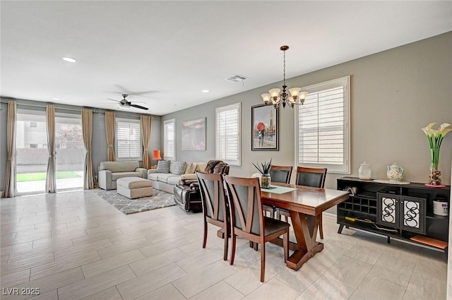 dining room featuring ceiling fan with notable chandelier and a wealth of natural light