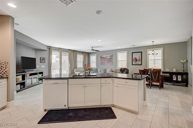 kitchen with dishwasher, sink, white cabinets, hanging light fixtures, and a kitchen island with sink